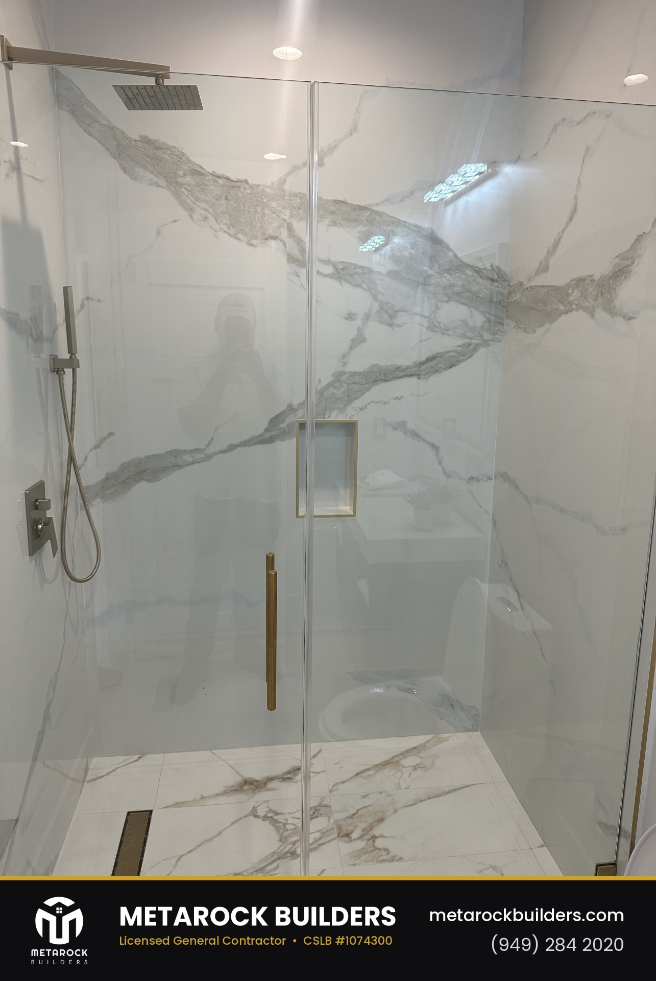 Bathroom remodel in Orange County by Sunward Builders Inc., completed after photo with dramatic book-matched marble slab shower walls, brushed brass hardware, and frameless glass enclosure