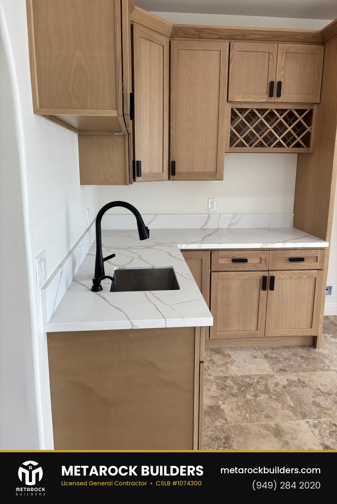 Kitchen remodel in Orange County by Sunward Builders Inc., completed after photo with calacatta quartz counters, matte black faucet, and oak cabinetry