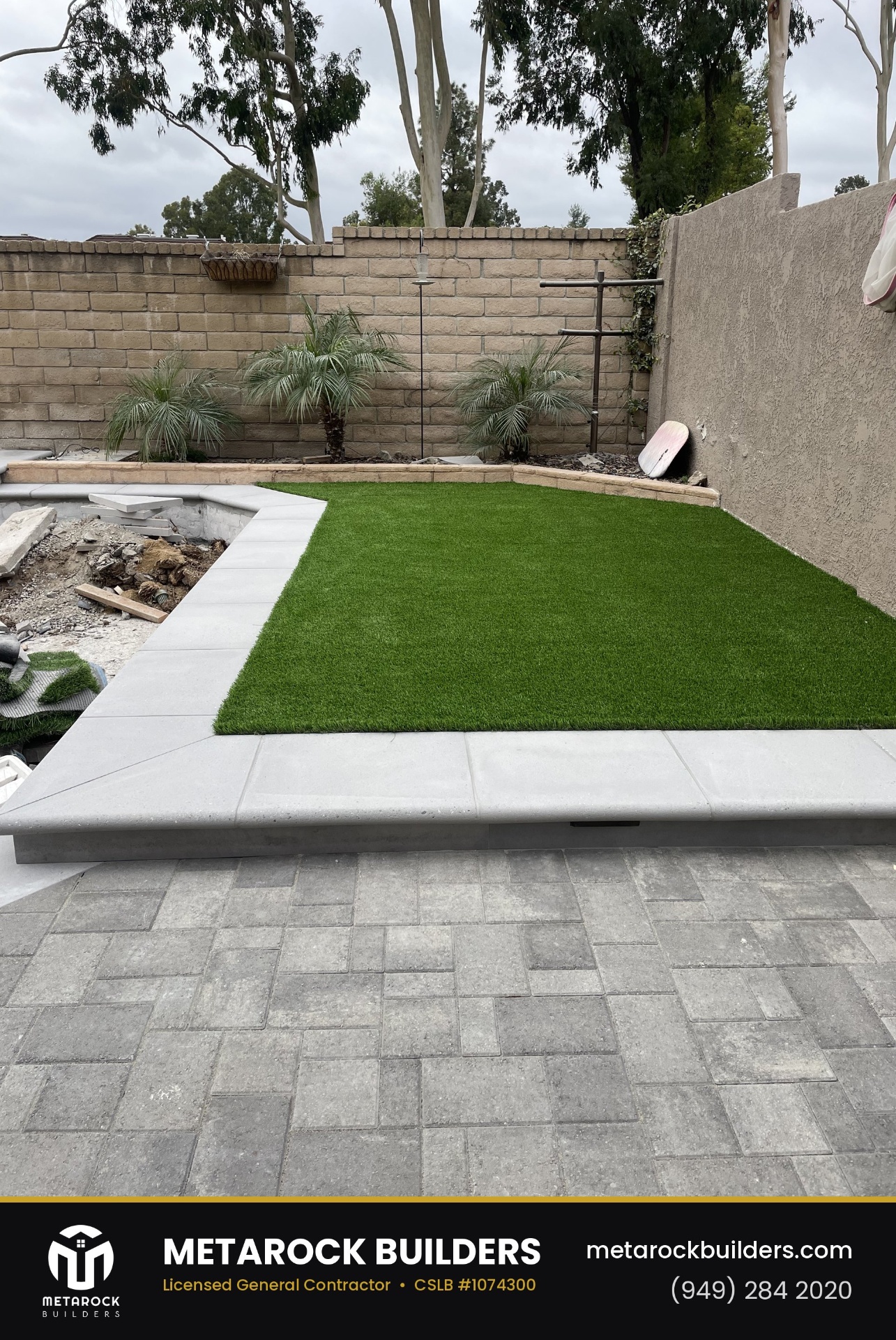 Landscaping in Orange County by Sunward Builders Inc., completed after photo with raised artificial-turf lawn, poured concrete curb, pygmy date palms, and gray paver patio