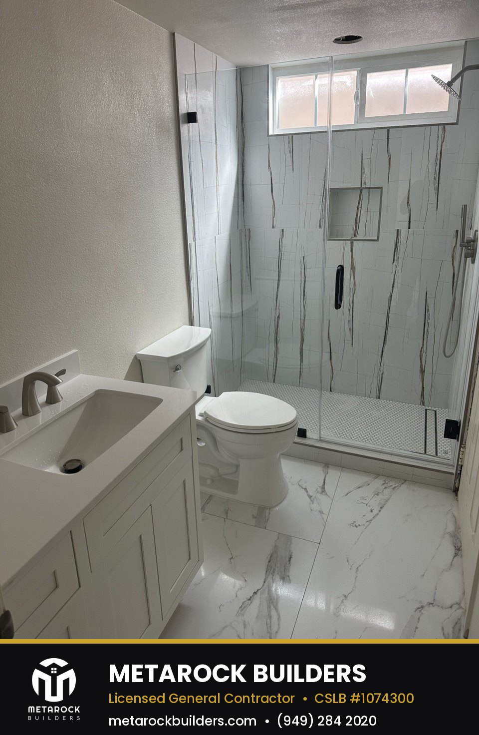 Bathroom remodel in Orange County by Sunward Builders Inc., completed after photo with marble-look tile shower, white shaker vanity, and frameless glass enclosure