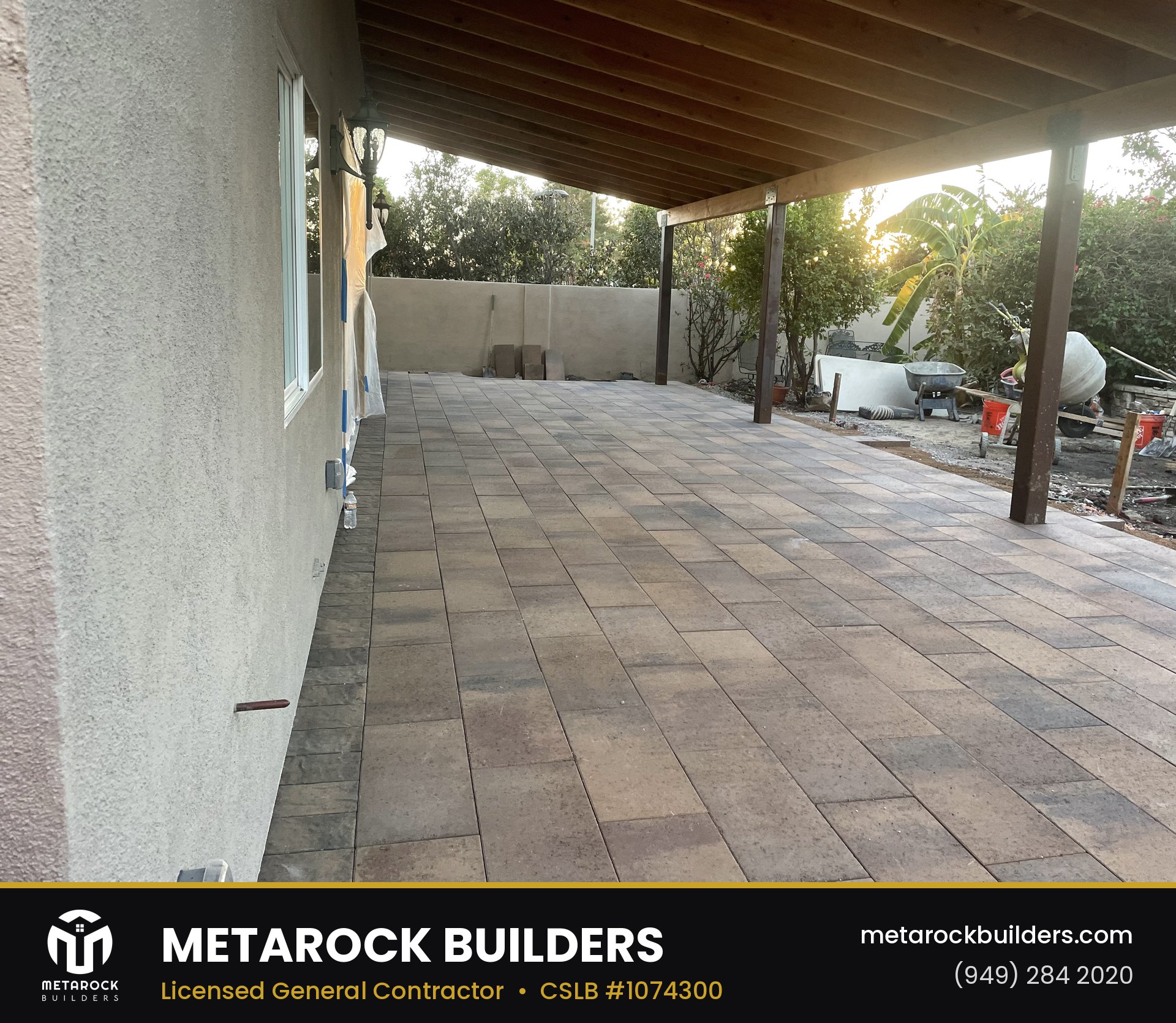 Paver patio in Orange County by Sunward Builders Inc., completed after photo with warm-tone stone pavers under a wood patio cover