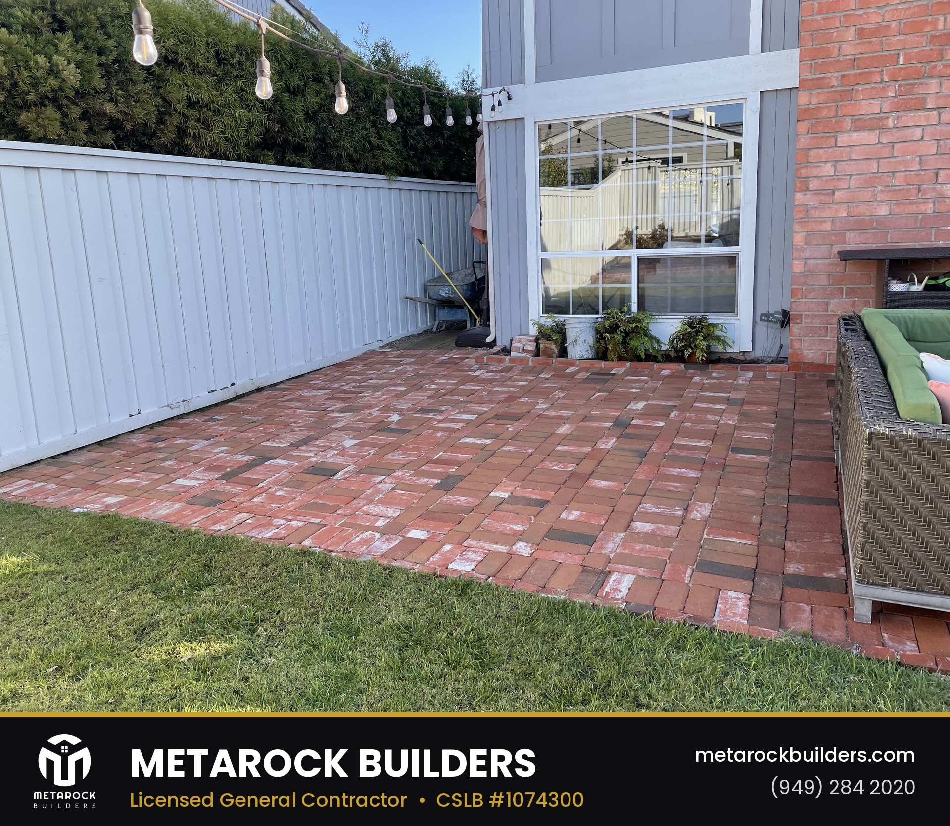 Landscaping in Orange County by Sunward Builders Inc., completed after photo with reclaimed red brick patio in basketweave pattern, string lights, and lawn border